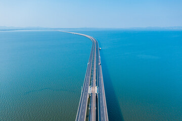 Aerial view of bridge road with cars over lake or sea