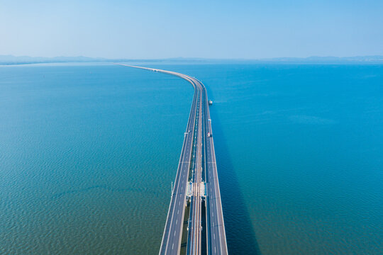 Aerial view of bridge road with cars over lake or sea