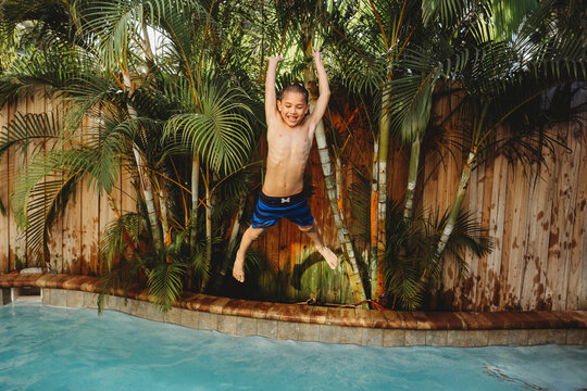 A boy jumping in a pool