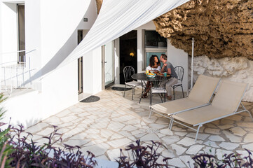 Couple having breakfast on terrace of country house