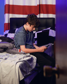 Teen Boy in Bedroom on Cell Phone
