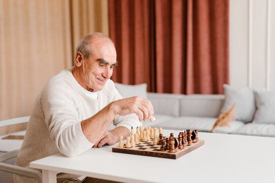 Senior man playing chess game alone