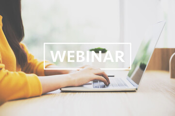 Woman using computer laptop on wood desk. She working at home and watching webinar and working on laptop