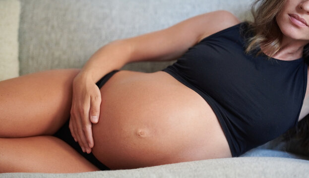 Pregnant 8 month woman touching belly