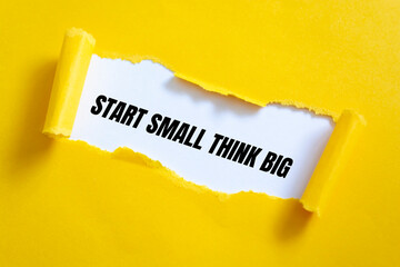 The text START SMALL THINK BIG behind torn yellow paper