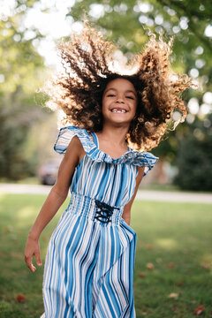 A beautiful, young african american child playing around her front yard and having fun