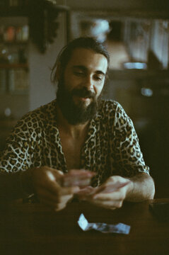 A man in a leopard shirt counts money