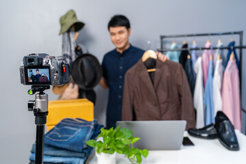 man selling hat and clothes online by camera live streaming, business online e-commerce at home