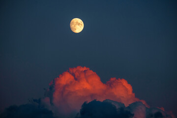98% full moon with red clouds