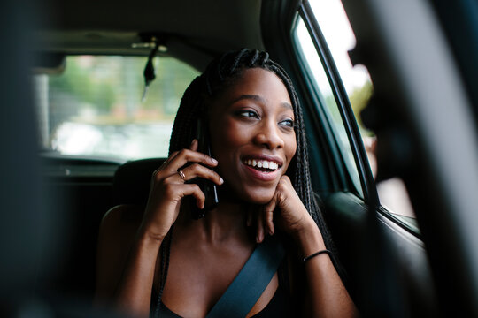 Young attractive woman inside a car talking on the phone