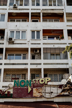Old rusty Karaoke sign on building facade on street during daytime