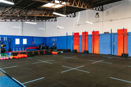 Barbells, medicinal balls and kettlebells on floor in modern gym