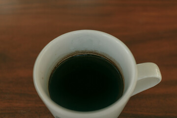 Close up of a cup of coffee on the table in the cafe.