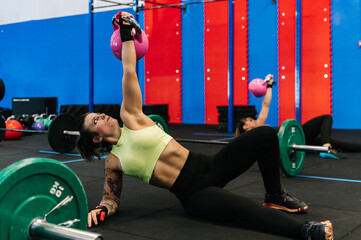 Woman lifting kettlebell on gym floor
