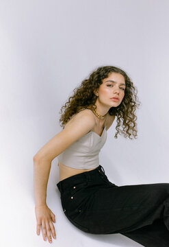 Fashion portrait of a beautiful woman with curly hair posing in the studio