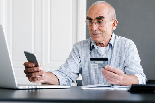 Senior man paying online with smartphone and credit card