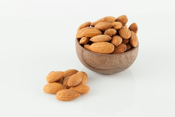 Wooden bowl with healthy dried fruit almonds; Photo on white background.