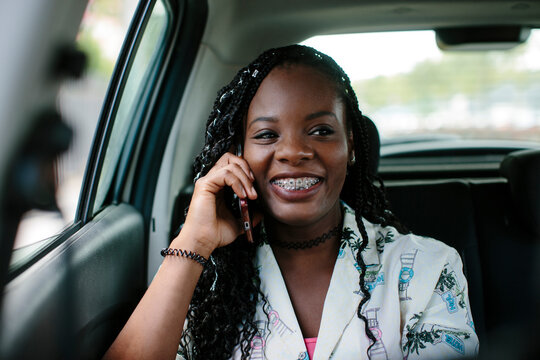 Young attractive woman inside a car talking on her smart phone.