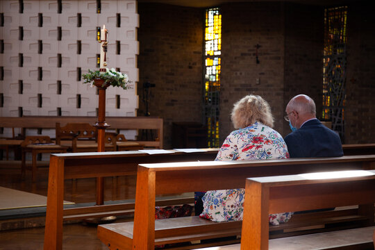 A senior couple attending mass with social distancing measures in place,