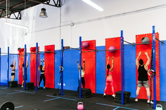 Unrecognizable athletes throwing balls against wall