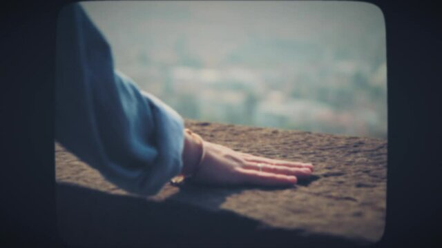 Woman's hand touching stone during old upper city walk. Vintage Film Look.