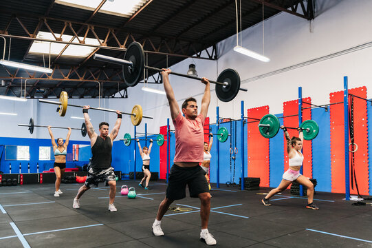 athletes lifting barbells over head