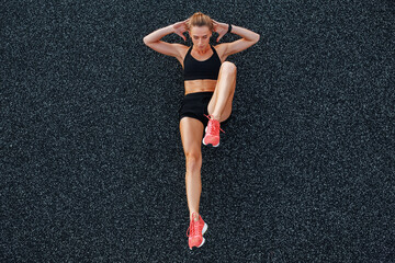 Fit woman doing abs exercise on ground