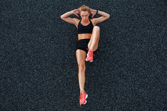 Fit woman doing abs exercise on ground