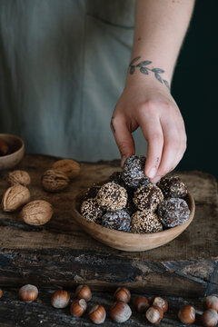 Tattooed Woman Picking Up Organic Cocoa Energy Balls