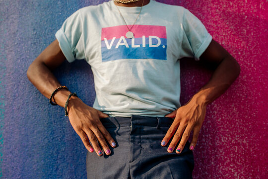 Torso of slender black male with hands on hips wearing VALID t-shirt