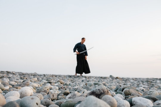 Blurred samurai on beach at sunset
