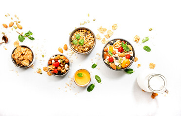 Muesli bowl, organic ingredients for healthy breakfast Granola, nuts, dried fruits, oatmeal, whole grain flakes on white background. Copy space, banner