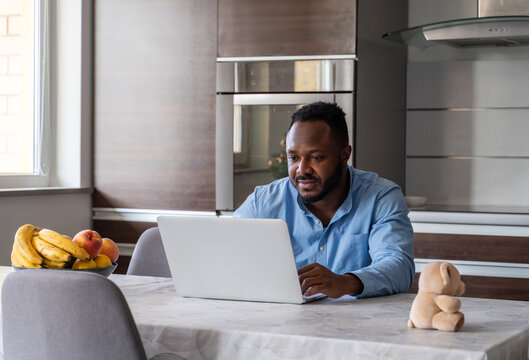 Happy Father Using Laptop At Kitchen