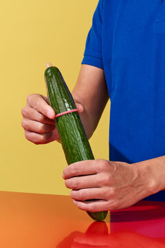 putting a condom on a cucumber