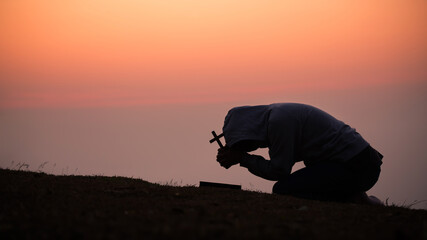 The girl bowed and prayed at sunset in the mountains