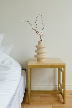 Nightstand with vase near bed