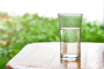 a glass of water on the table in the garden