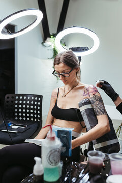 Female artist in the process of making a tattoo.