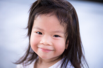 Closeup Asian little cute girl with a sweet smile. Child looking at the camera. Happy children. Adorable kids aged 3-4 years old.