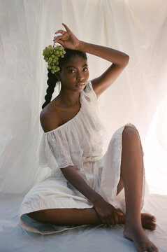 Dark Skinned Woman Holding Up Grapes