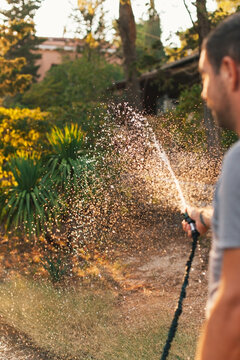 Unrecognizable man watering flowers
