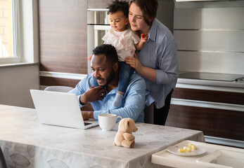Young Family Using Laptop At Kitchen