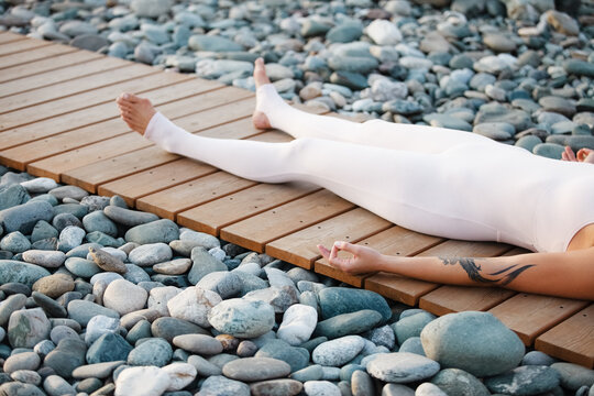 Crop woman lying on path in Corpse pose