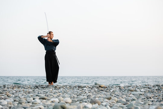 Samurai walking with sword near sea