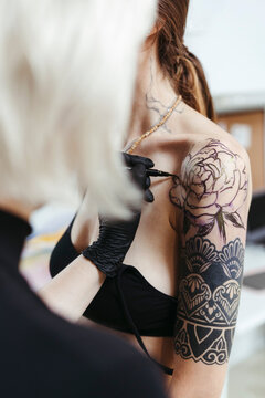 Female artist in the process of making a tattoo.