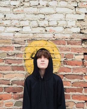Teen Boy Against Brick Wall Looking Up
