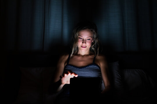Woman Looks at Tablet in the Dark
