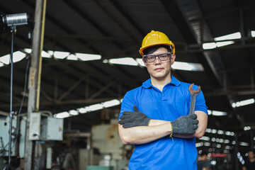 portrait image asian engineer men wearing uniform safety and holding wrench tool in factory.  male professional maintenance repair machine at industrial.