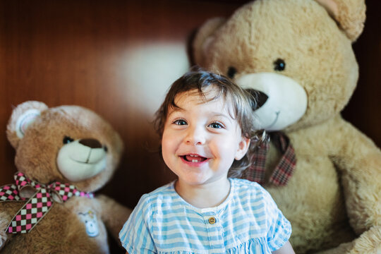 Naklejki Toddler surrounded by teddy bears