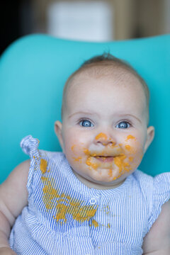 Baby sitting and eating porridge